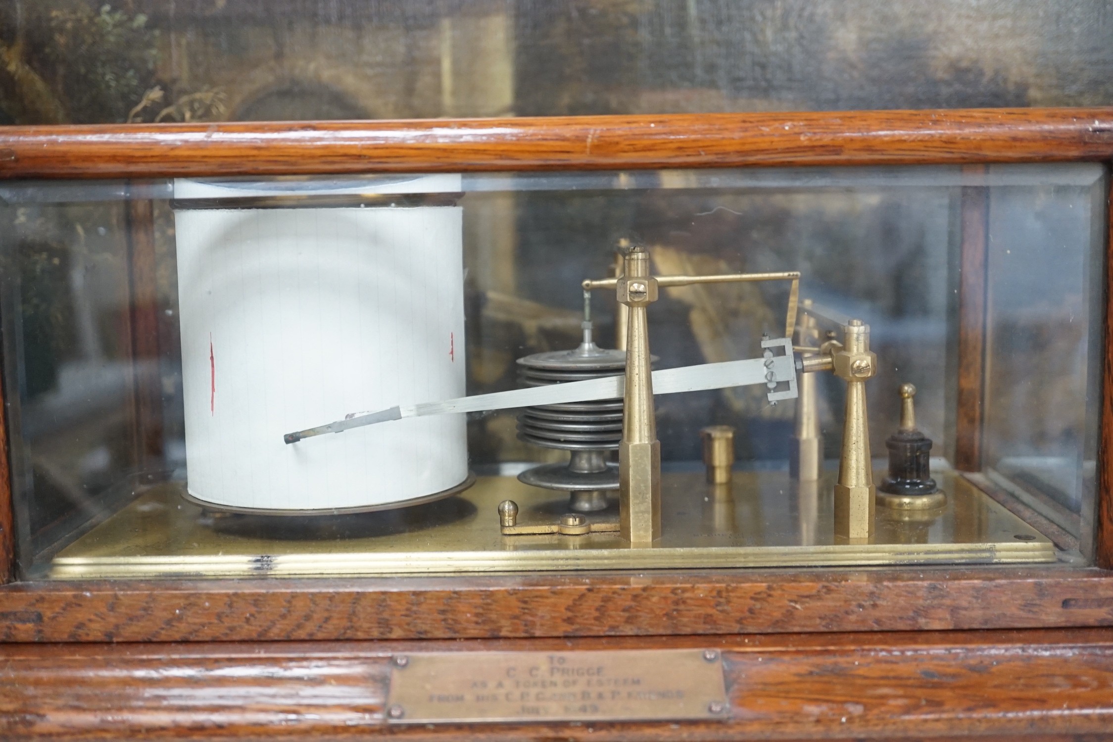 A Negretti and Zambra oak cased barograph number R/20613 with plaque reading ‘To C.C. Prigge as a token of esteem from his C.P.C. and B&P friends July 1949’